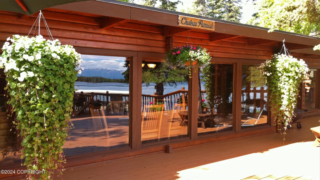 Main cabin lakeside windows framed by hanging flower baskets