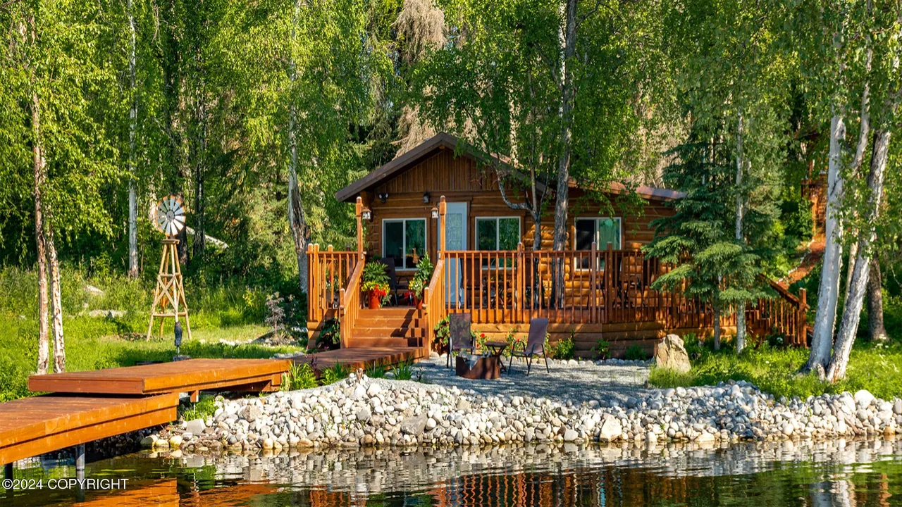 Guest cabin at the shoreline with ornamental windmill and small dock
